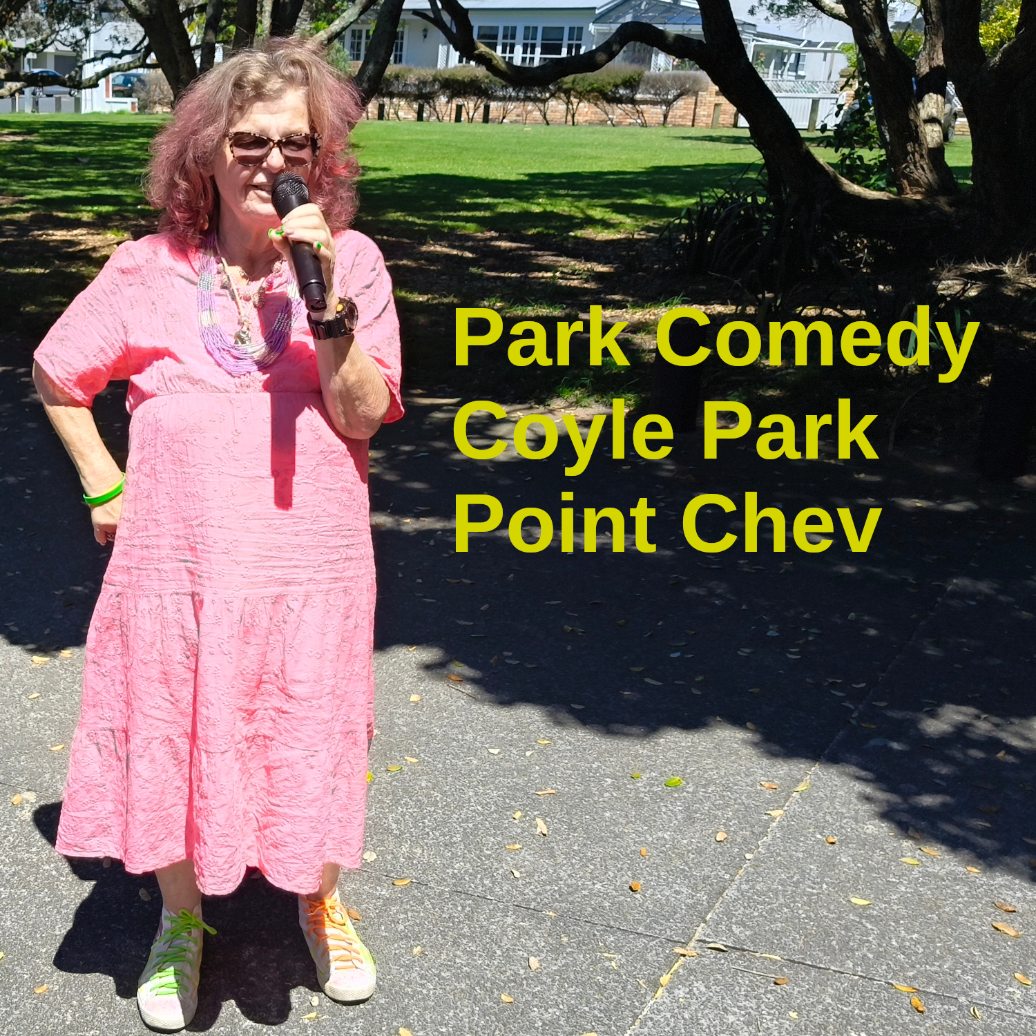 Tessa, mic in hand, stands in front of the glade in Coyle Park where we like to perform.